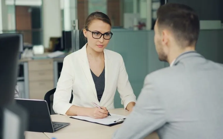 Two people sitting across an office desk in a meeting