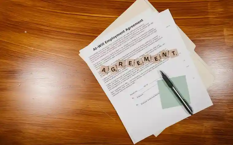 An employment contract document lying on a desk with a pen