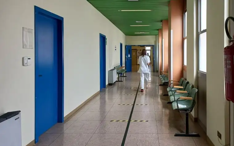 Rear view of a medical worker walking down a hospital corridor