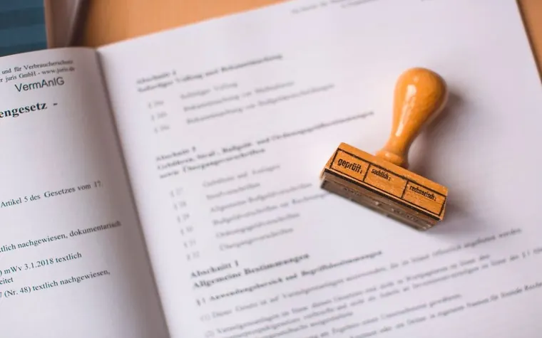 A wooden stamp and a contract document on a desk