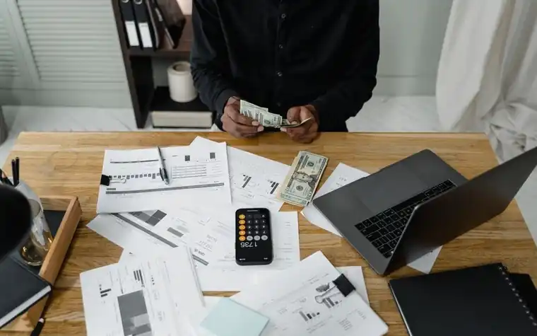 책상 위 영수증 서류를 정리하며 계산하는 손